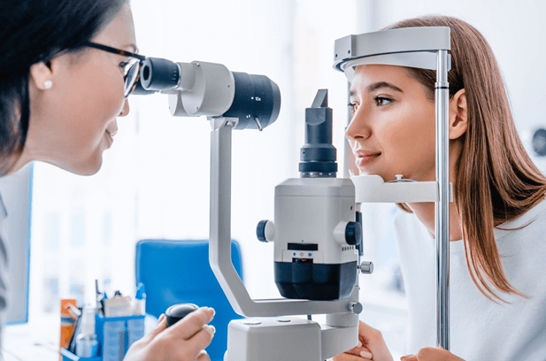 Side-perspective-of-an-eye-doctor-using-a-microscope-and-slit-lamp-to-view-a-patients-eye